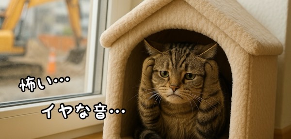 工事の音に怯えて耳を塞ぐ猫、大きな音によるストレスのイメージ